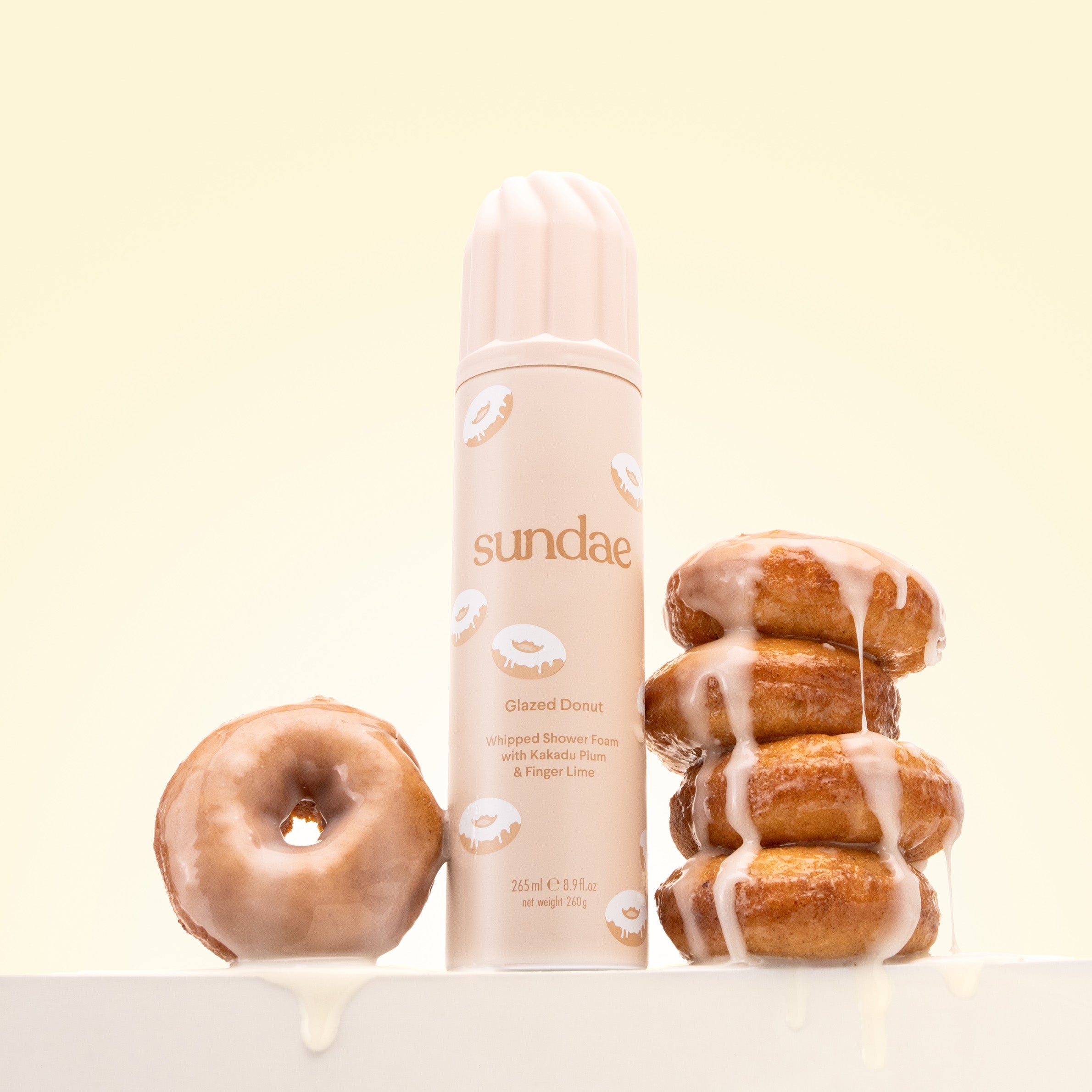 Sundae skincare product with glazed donuts on a light yellow background